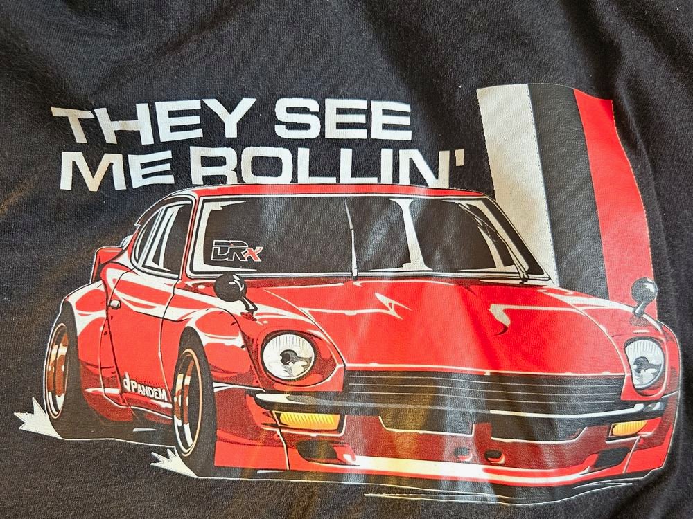 Estampa colorida de um carro em camiseta preta, trabalho da DRx
